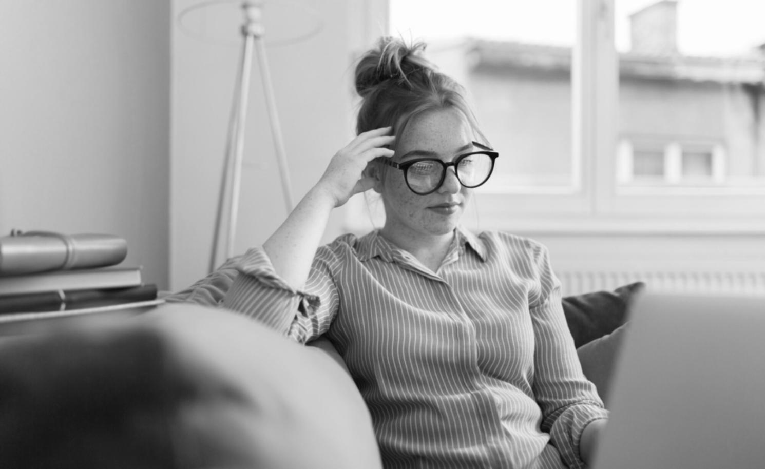 Students engaged in economic data analysis workshop with multiple computer screens showing financial charts
